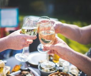 People cheers'ing glasses of LBW wine at a picnic