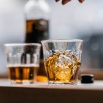 Two glasses of mead in the foreground with a bottle in the background