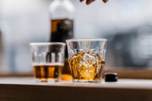 Two glasses of mead in the foreground with a bottle in the background