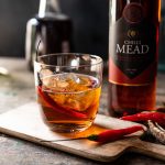 Mead in a glass with a paring knife and chillis