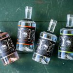 Bottles of LBW Gin on a green wood backdrop