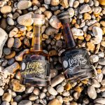 Bottles of Jack lugger rum on a stony beach